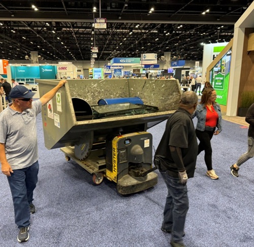 moving a bin of glass to be recycled on the GlassBuild show floor