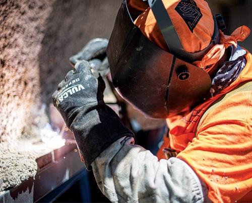 worker with face shield and gloves working on a jobsite