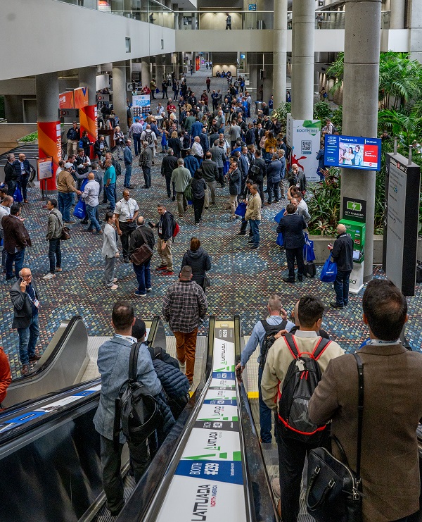 crowd comes down the escalator and through the entrance at GlassBuild