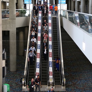 people descend the escalators, showing branding