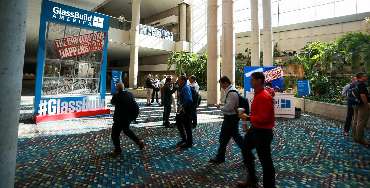 People walking into the entrance of the GlassBuild trade show floor in 2019
