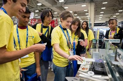 students visit an exhibitor booth at GlassBuild