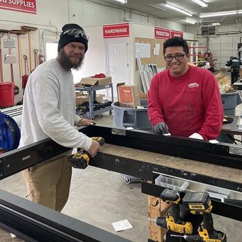 two student apprentices work in the shop