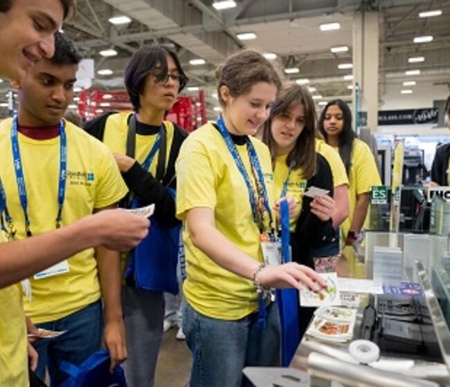 students visit an exhibitor booth at GlassBuild
